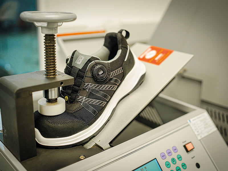 Black and white sneaker being processed by a machine with a blurred background